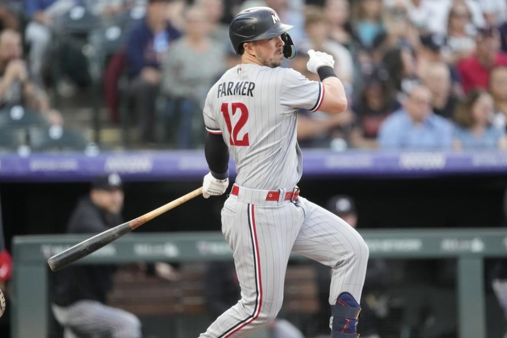 Minnesota Twins' Kyle Farmer follows the flight of his RBI single off Colorado Rockies starting pitcher Ty Blach in the first inning of a baseball game Friday, Sept. 29, 2023, in Denver. (AP Photo/David Zalubowski)