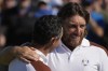 Europe's Tommy Fleetwood, right, hugs Europe's Rory Mcilroy on the 17th green after they won their morning Foursomes match at the Ryder Cup golf tournament at the Marco Simone Golf Club in Guidonia Montecelio, Italy, Saturday, Sept. 30, 2023. (AP Photo/Alessandra Tarantino)
