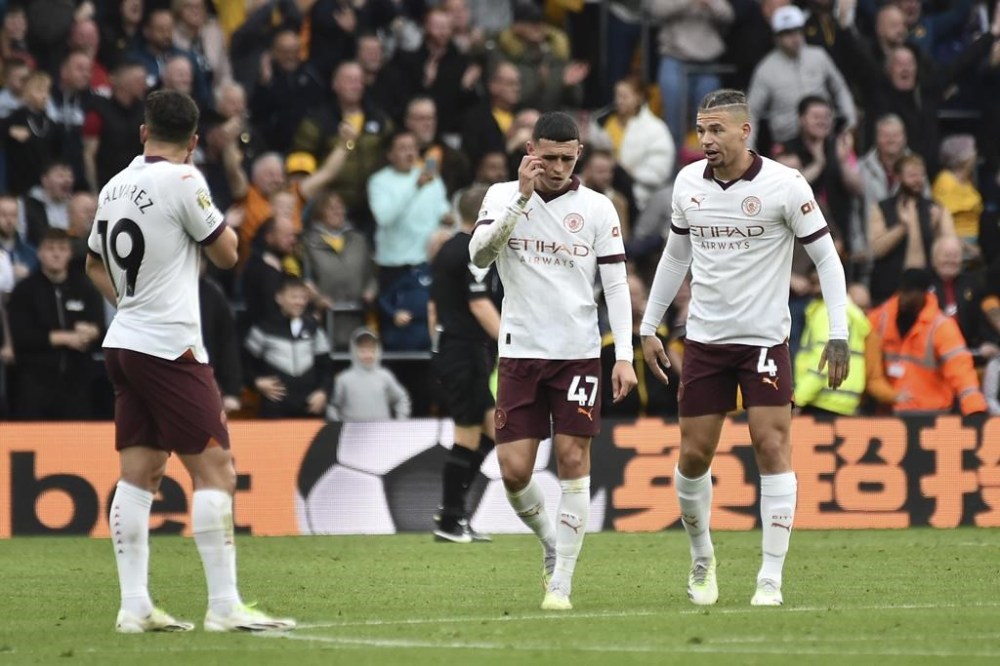 Manchester City's Kalvin Phillips, right, Manchester City's Phil Foden, center, and Manchester City's Julian Alvarez react Wolverhampton Wanderers' Hwang Hee-chan scores his side's second goal during the English Premier League soccer match between Wolverhampton Wanderers and Manchester City at the Molineux Stadium in Wolverhampton, England, Saturday, Sept. 30, 2023. (AP Photo/Rui Vieira)
