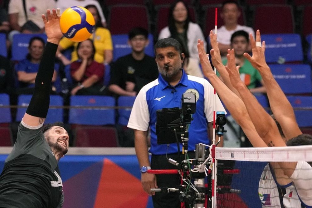 Canada's Stephen Timothy Maar, left, hits the ball during their game against Italy at the Men's Volleyball Nations League leg in Manila, Philippines on Thursday July 6, 2023. Canada emerged victorious in its opening match of a men's volleyball Olympic qualification tournament early on Saturday. THE CANADIAN PRESS/AP-Aaron Favila
