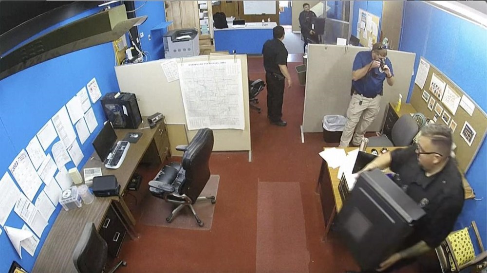 FILE - This image made from surveillance video provided by the Marion County Record shows Marion, Kan., Police Department confiscating computers and cellphones from the publisher and staff of the Marion County Record, Aug. 11, 2023, in Marion, Kan. The police chief who led the highly criticized raid of the small Kansas newspaper is suspended, the mayor confirmed to The Associated Press on Saturday, Sept. 30. Marion Mayor Dave Mayfield in a text said he suspended Chief Gideon Cody on Thursday, Sept. 28. (Marion County Record via AP, File)