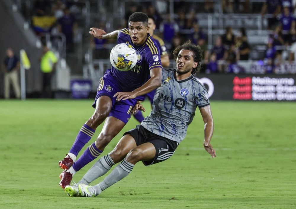 Orlando City midfielder Wilder Cartagena, left, and CF Montreal midfielder Ahmed Hamdi vie for the ball during the first half of an MLS soccer match Saturday, Sept. 30, 2023, in Orlando, Fla. (AP Photo/Kevin Kolczynski)