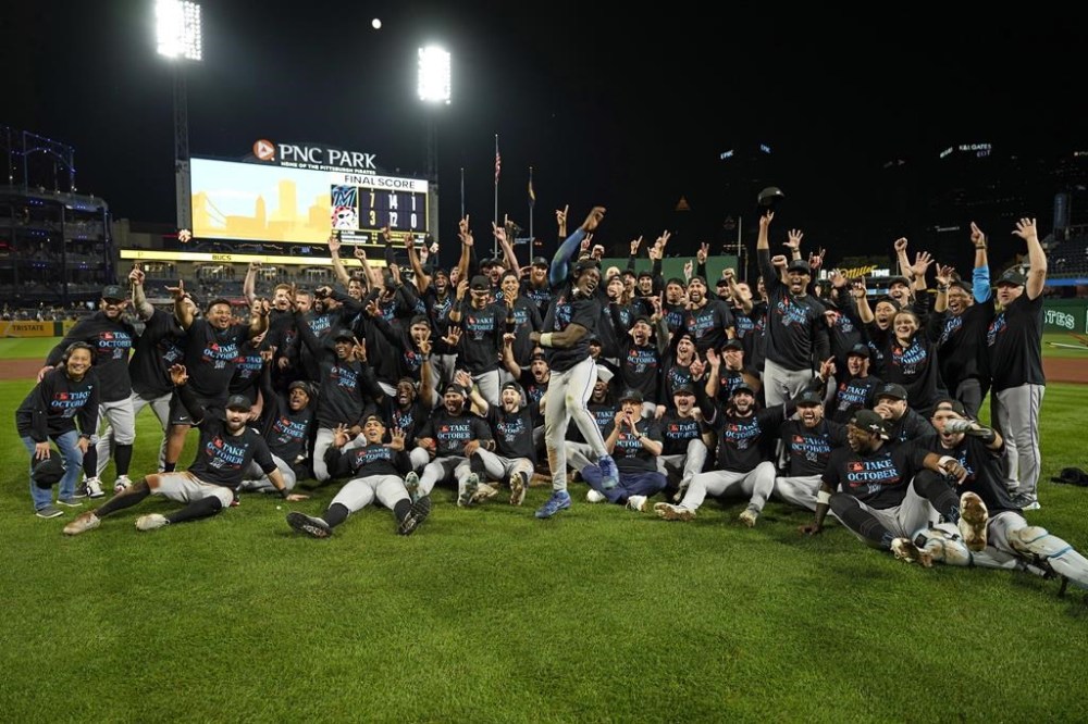 The Miami Marlins pose on the field at PNC Park in Pittsburgh after clinching a playoff berth with a win over the Pittsburgh Pirates in a baseball game Saturday, Sept. 30, 2023. (AP Photo/Gene J. Puskar)