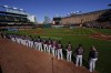 Boston Red Sox players line up for a moment of silence to honor former pitcher Tim Wakefield, who passed away earlier in the day at the age of 57, prior to a baseball game against the Baltimore Orioles, Sunday, Oct. 1, 2023, in Baltimore. (AP Photo/Julio Cortez)