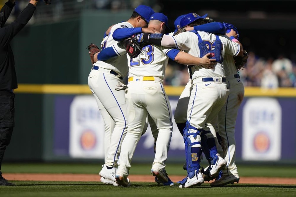 The Seattle Mariners infield, including first baseman Ty France and catcher Luis Torrens dance to celebrate win over the Texas Rangers in a baseball game, Sunday, Oct. 1, 2023, in Seattle. (AP Photo/Lindsey Wasson)