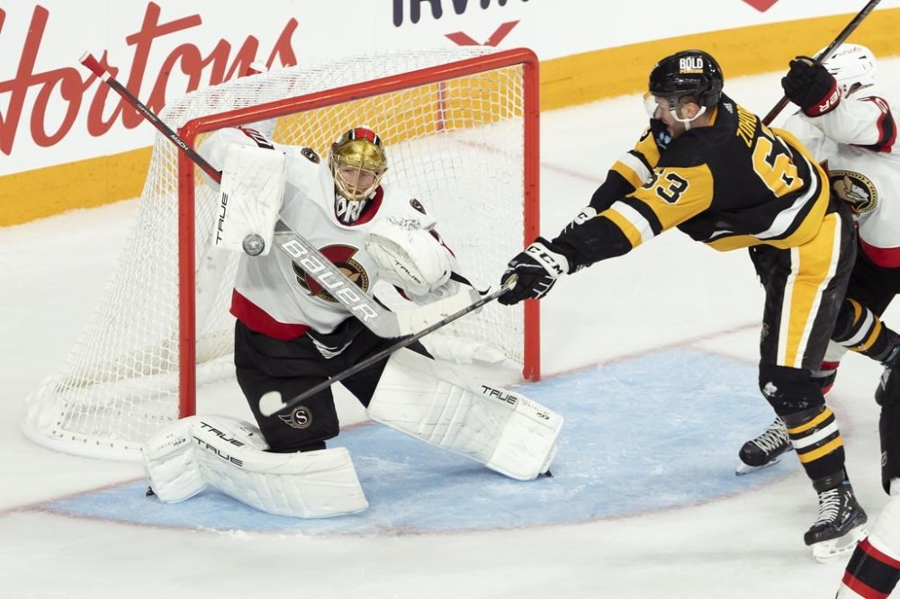 Ottawa Senators goaltender Joonas Korpisalo, left, makes a save in front of Pittsburgh Penguins' Radim Zohorna during second period NHL preseason hockey action in Halifax on Monday, Oct. 2, 2023. THE CANADIAN PRESS/Darren Calabrese