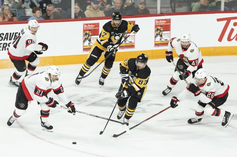 Pittsburgh Penguins' Sidney Crosby, bottom centre, makes a pass while surrounded by Ottawa Senators during first period NHL preseason hockey action in Halifax on Monday, Oct. 2, 2023. THE CANADIAN PRESS/Darren Calabrese