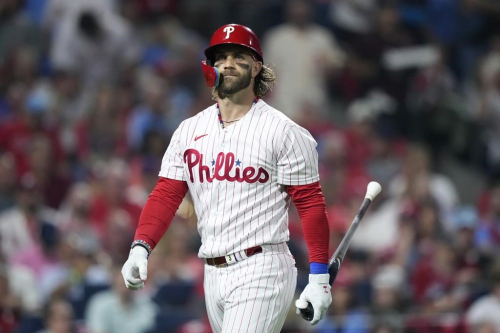 Philadelphia Phillies' Bryce Harper walks to the dugout after striking out against Miami Marlins pitcher A.J. Puk during the fifth inning of Game 1 in an NL wild-card baseball playoff series, Tuesday, Oct. 3, 2023, in Philadelphia. (AP Photo/Matt Slocum)