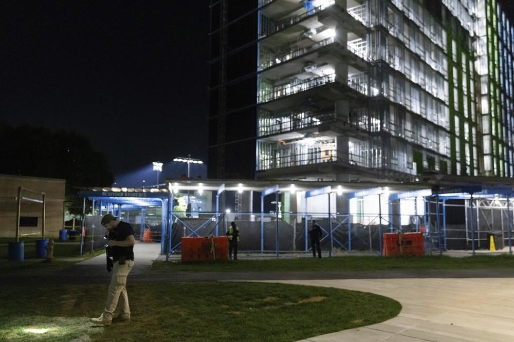 An ATF officer searches for evidence in front of a building at Morgan State University after a shooting, Wednesday, Oct. 4, 2023, in Baltimore. (AP Photo/Julia Nikhinson)