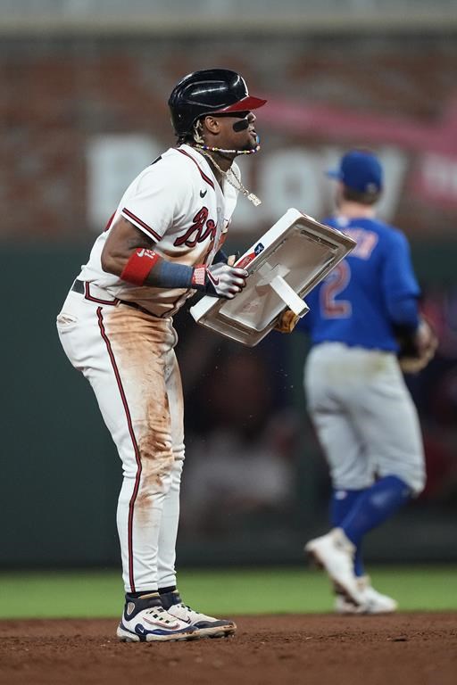 Atlanta Braves' Ronald Acuna Jr. (13) holds up the bag after stealing second base in the 10th inning of a baseball game against the Chicago Cubs, Wednesday, Sept. 27, 2023, in Atlanta. The stolen base was Acuna's 70th of the season. (AP Photo/John Bazemore)