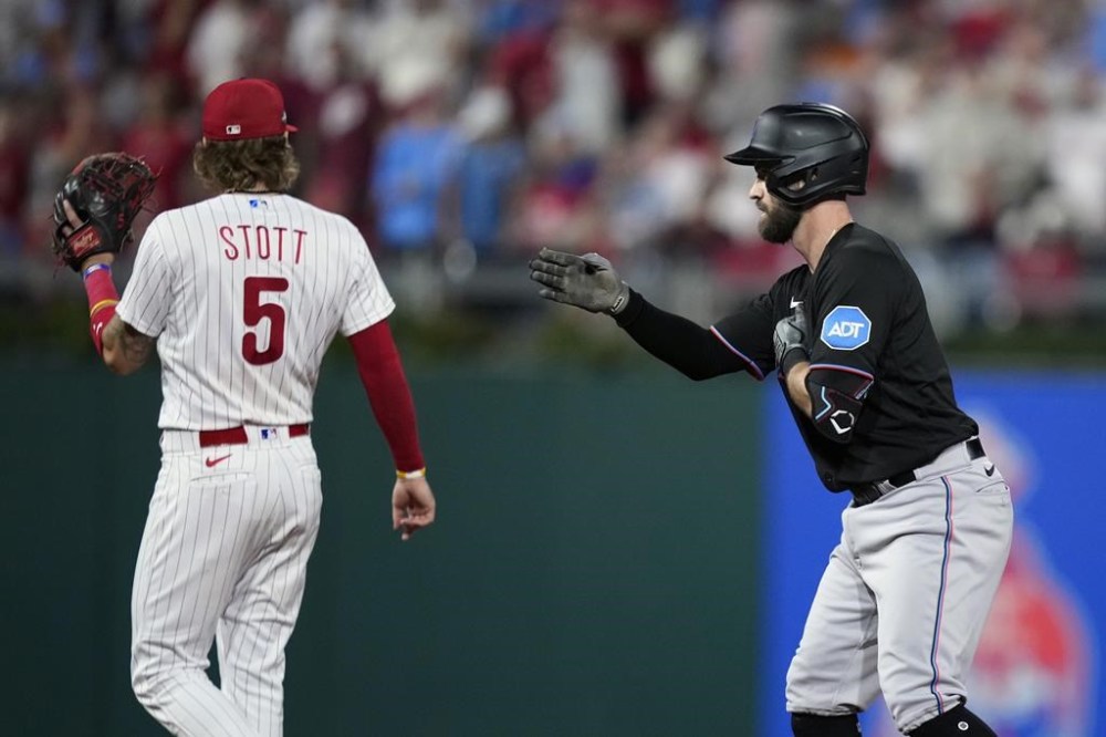 Miami Marlins' Jon Berti, right, reacts after hitting a double against Philadelphia Phillies pitcher Aaron Nola during the third inning of Game 2 in an NL wild-card baseball playoff series, Wednesday, Oct. 4, 2023, in Philadelphia. (AP Photo/Matt Slocum)