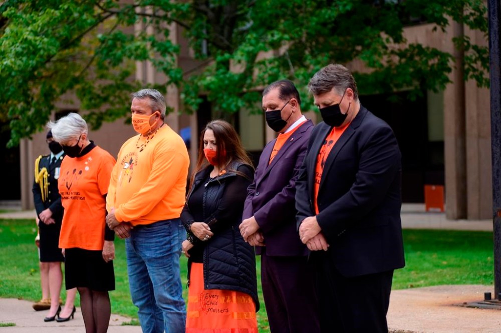 P.E.I. Lt.-Gov. Antoinette Perry, Roderick “Junior” Gould, chief of Abegweit First Nation, Darlene Bernard, chief of Lennox Island First Nation, Sen. Brian Francis and P.E.I. Premier Dennis King, observe two minutes of silence in honour of the residential school victims during a National Day for Truth and Reconciliation service in Charlottetown, Thursday, Sept. 30, 2021. A First Nation chief and the mayor of a small P.E.I. community are calling for a village councillor’s resignation over a hateful anti-Indigenous sign posted on his property. THE CANADIAN PRESS/Brian McInnis