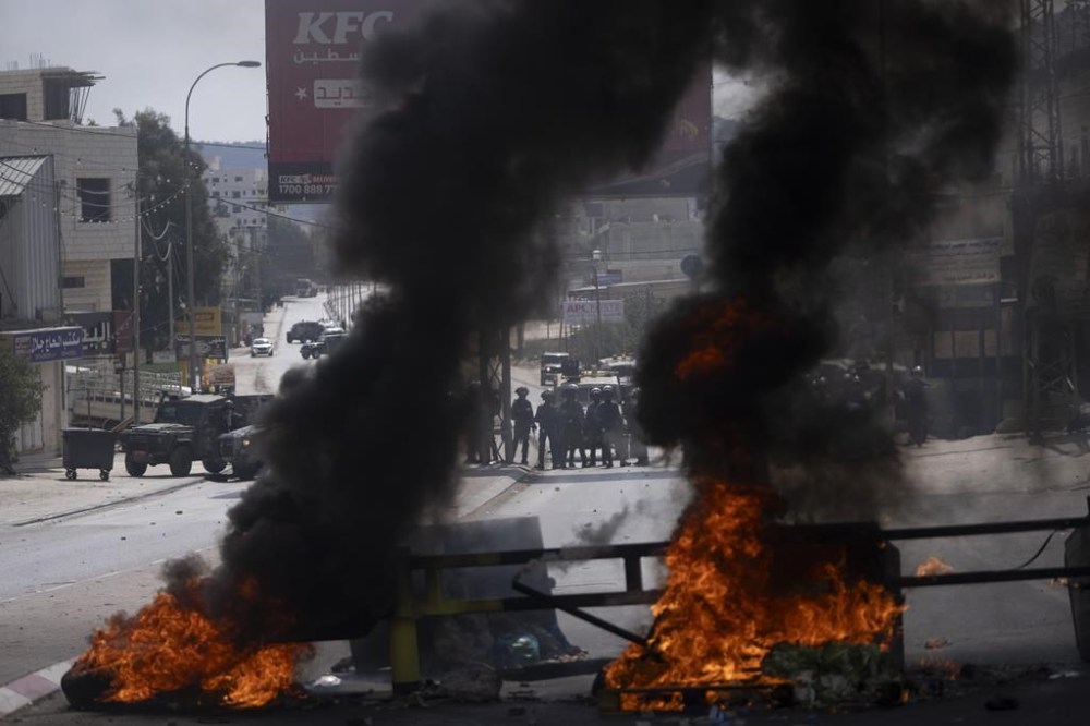 Israeli border police blocks the roads and clash with Palestinian protesters during the funeral of Labeeb Dumaidi, 19 in the West Bank village of Hawara, near Nablus, Friday, Oct. 6, 2023. The teenager's death, coming as tensions escalate during the Jewish holiday season, marked the latest incident a surge of Israeli-Palestinian fighting. (AP Photo/Nasser Nasser)