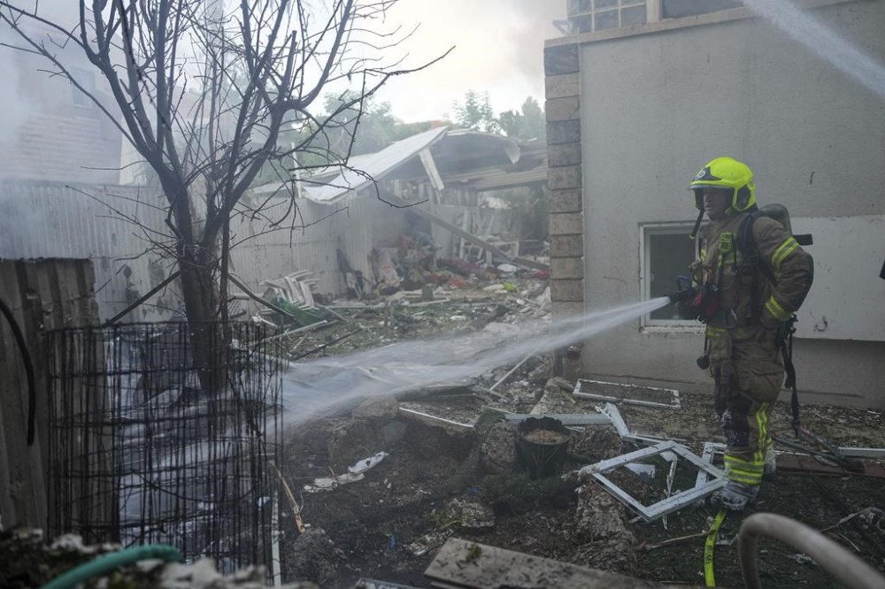 Israeli firefighters extinguish fire after a rocket fired from the Gaza Strip hit a house in Ashkelon, southern Israel, Saturday, Oct. 7, 2023. (AP Photo/Tsafrir Abayov)