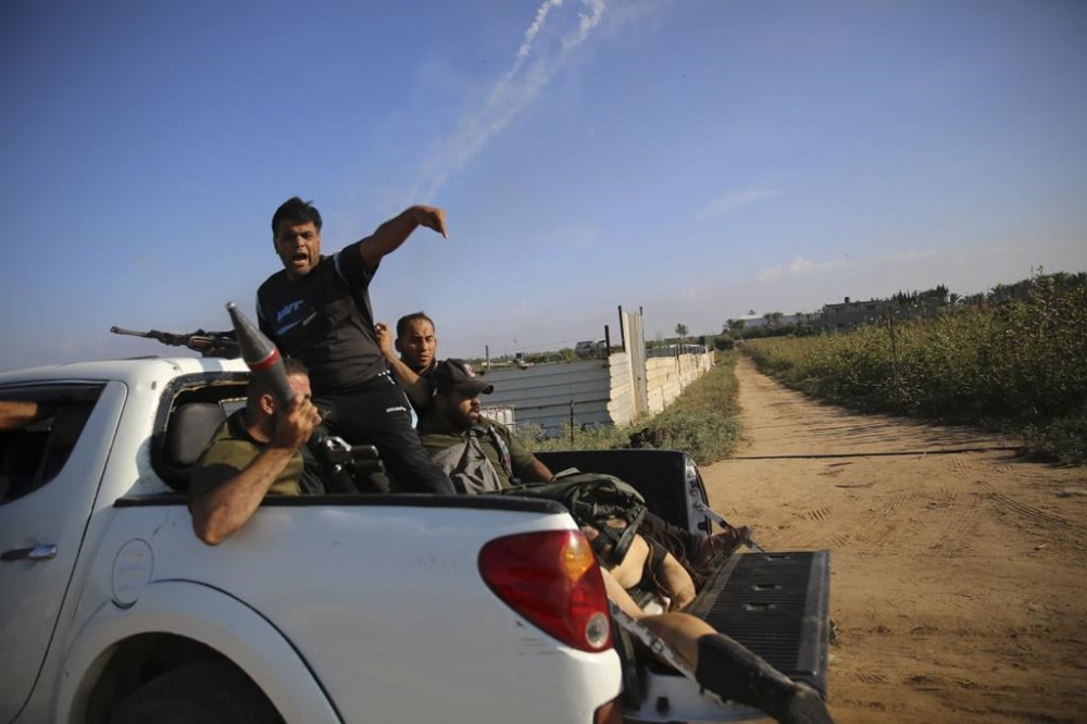Palestinian militants drive back to the Gaza Strip with the body of an Israeli soldier on Saturday, Oct. 7, 2023. The militant Hamas rulers of the Gaza Strip carried out an unprecedented, multi-front attack on Israel at daybreak Saturday, firing thousands of rockets as dozens of Hamas fighters infiltrated the heavily fortified border in several locations by air, land, and sea and catching the country off-guard on a major holiday. (AP Photo/Ali Mahmud)
