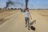 CORRECTS LOCATION Palestinians walk away from the kibbutz of Kfar Azza, Israel, near the fence with the Gaza strip on Saturday, Oct. 7, 2023. The militant Hamas rulers of the Gaza Strip carried out an unprecedented, multi-front attack on Israel at daybreak Saturday, firing thousands of rockets as dozens of Hamas fighters infiltrated the heavily fortified border in several locations by air, land, and sea and catching the country off-guard on a major holiday. (AP Photo/Hassan Eslaiah)