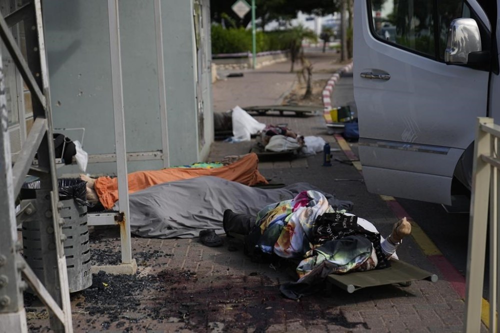 Civilians killed by Palestinian militants lie covered in Sderot, Israel, on Saturday, Oct. 7, 2023. Palestinian militants in the Gaza Strip infiltrated Saturday into southern Israel and fired thousands of rockets into the country while Israel began striking targets in Gaza in response. (AP Photo/Ohad Zwigenberg)