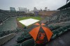 A fan sits in the stand with an umbrella as they wait for the start of Game 1 of an American League Division Series baseball game between the Baltimore Orioles and the Texas Rangers, Saturday, Oct. 7, 2023, in Baltimore, Md. (AP Photo/Julio Cortez)
