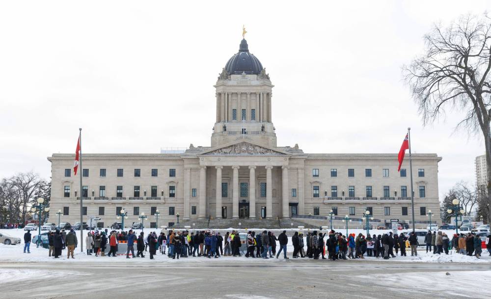 MIKE DEAL / WINNIPEG FREE PRESS
An MGEU picket line of a few hundred people marches around the Manitoba Legislative Building Tuesday morning.