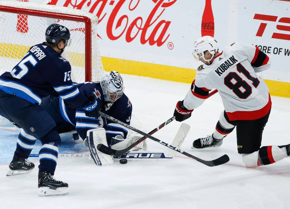 Winnipeg Jets goaltender Connor Hellebuyck saves the shot from Ottawa Senators’ Dominik Kubalik (81) as Jets’ Rasmus Kupari (15) defends during the third period of NHL preseason. (John Woods / The Canadian Press)