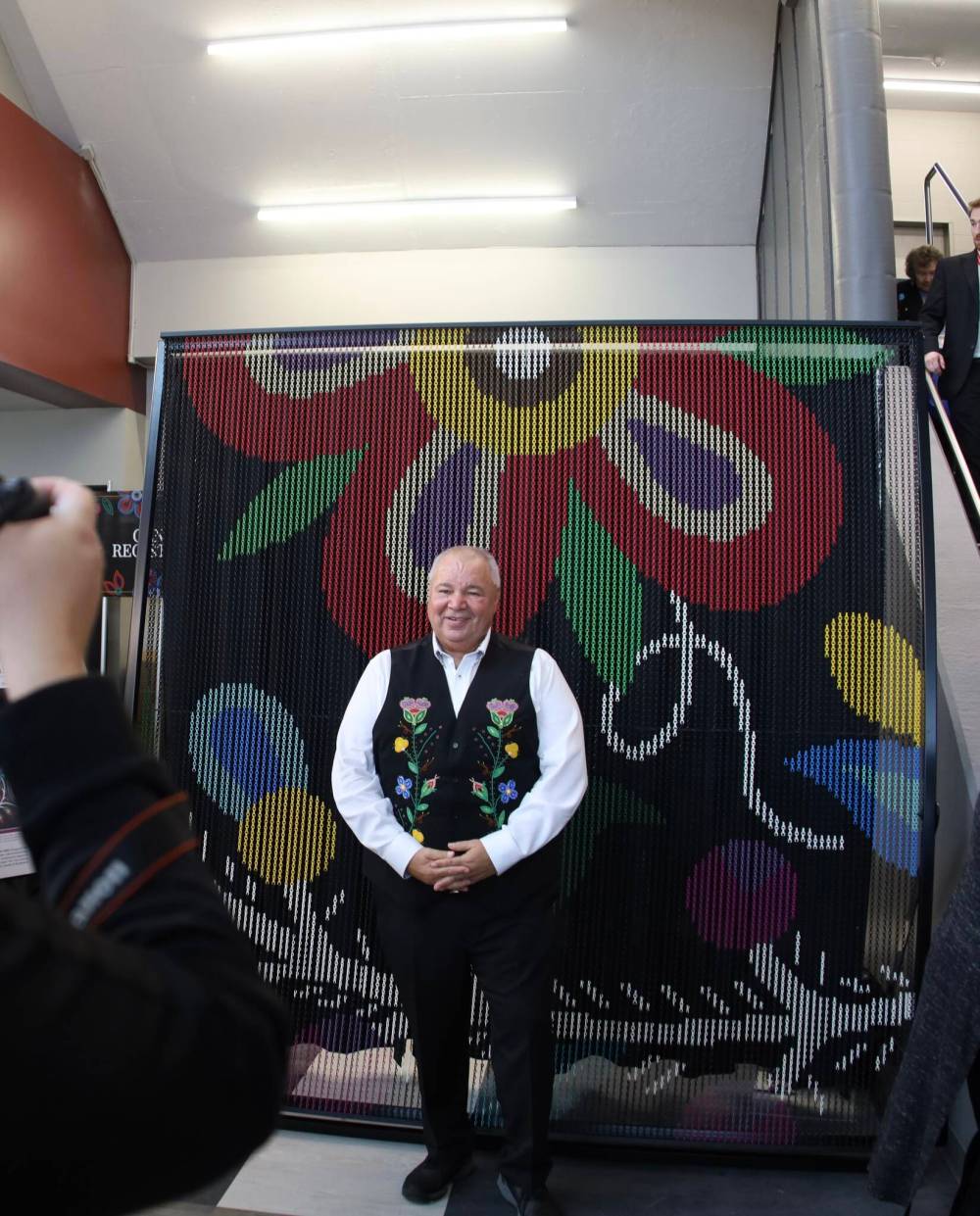 Manitoba Métis Federation president David Chartrand unveils a portion of the installation, which is expected to be completed in 2026. (Katrina Clarke / Winnipeg Free Press)