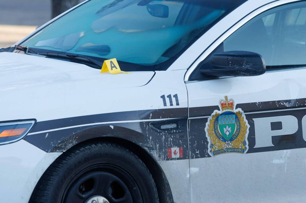 The WPS forensics unit investigating at a scene that included a police car at Broadway and Sherbrook Avenue Monday morning. (Mike Deal / Winnipeg Free Press)