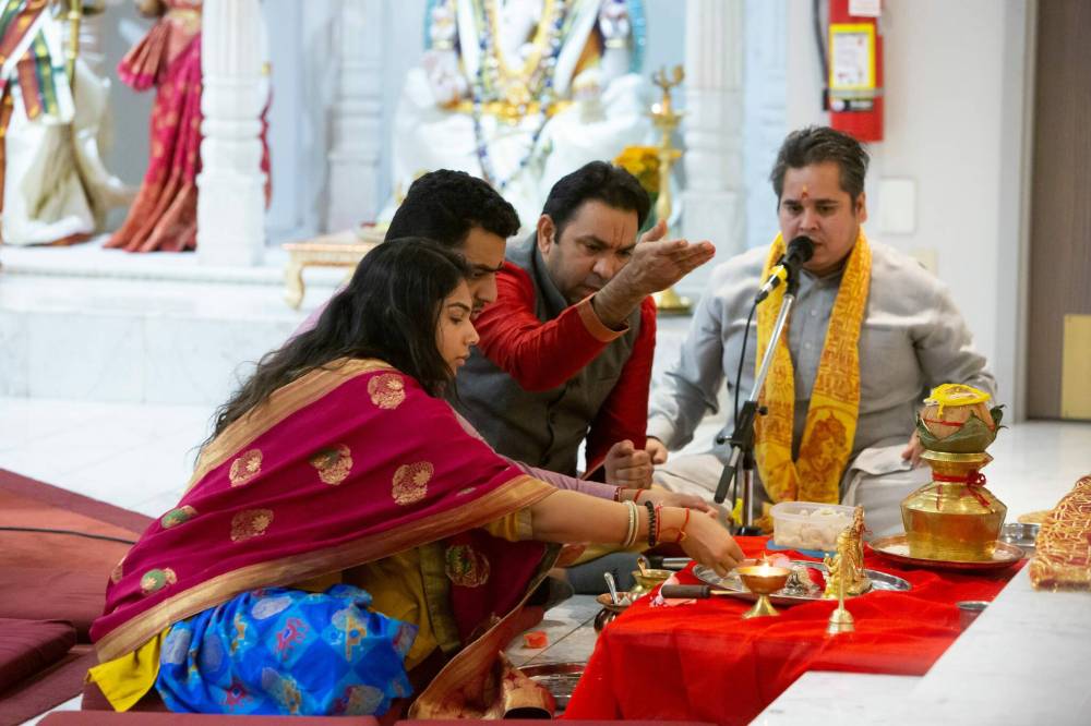 BROOK JONES / WINNIPEG FREE PRESS
                                Pandit Shrikant Sharma (second from right) and Pandit Vimlesh Jha (far right), who are priests with the Hindu Society of Manitoba, lead Anand Amin (second from left) and Shivani Patel (far left) in performing Lakshmi Mata Puja, which is also known as an offering to the Goddess Durga, who is in the form of Kushmanda on the fourth day of the festival, in front of the altar.