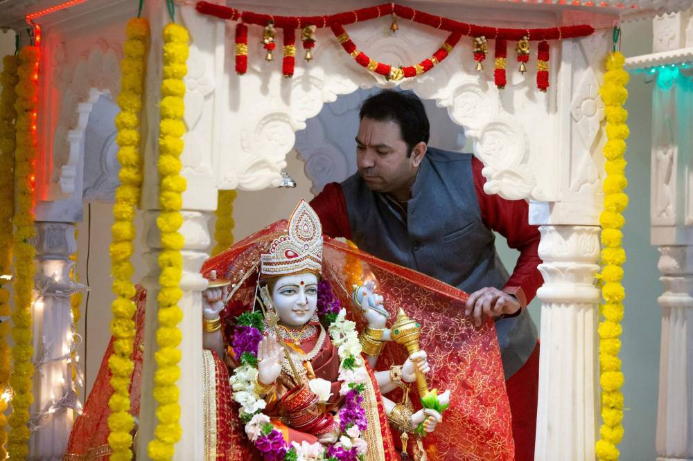 BROOK JONES / WINNIPEG FREE PRESS
                                Pandit Shrikant Sharma, who is a priest with Hindu Society of Manitoba, wraps a shawl around the Hindu Goddess Durga, who is appearing as Kushmanda on the fourth day of the festival.