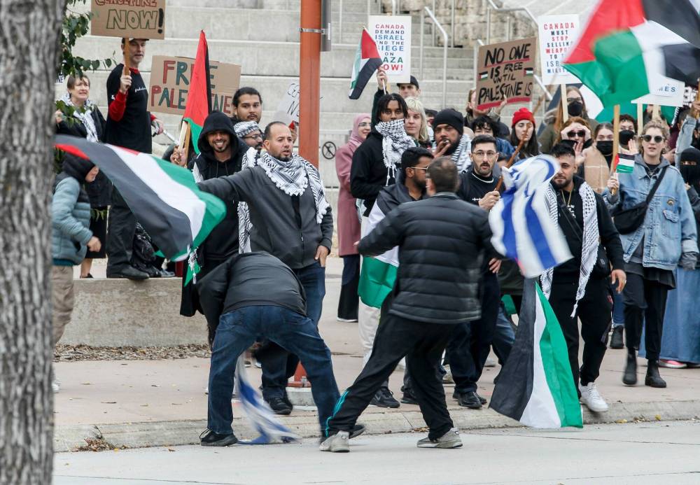 JOHN WOODS / WINNIPEG FREE PRESS
Israeli supporters retrieve a flag taken by Palestinian supporters.