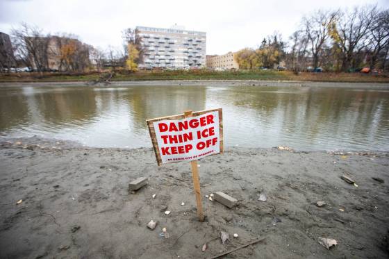 Thin ice signs installed along the Assiniboine River near the Legislative Building on Monday.  (Mikaela MacKenzie / Winnipeg Free Press)