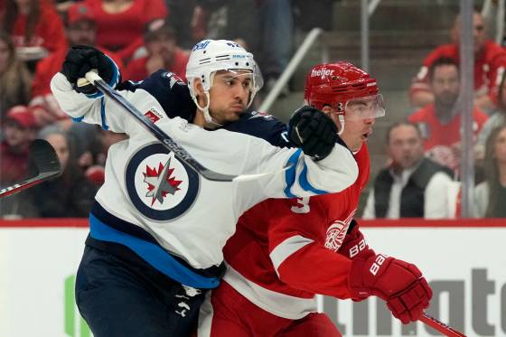 Jets forward Nino Niederreiter works his way around Red Wings defenceman Justin Holl Thursday night in Detroit. (Carlos Osorio / The Associated Press)