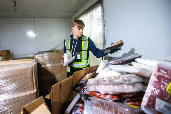 Volunteer Rouven Hoffmann stocks the freezer with meat at Harvest Manitoba. (Mikaela MacKenzie / Winnipeg Free Press)