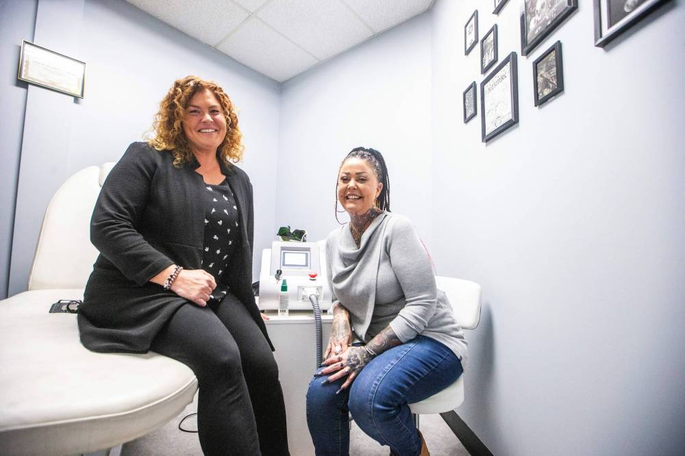 MIKAELA MACKENZIE / WINNIPEG FREE PRESS
Michelle de Groot (WPS gang prevention coordinator, left), and Della Steinke (tattoo removal artist and mentor), in the tatto removal office at the Mother Ink Tattoo Removal’s grand opening Friday.