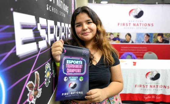 Grade 9 student Naeyli Desjarlais, 14, of Brokenhead First Nation, shows off her design award. She and her team secured the top prize for their design which incorporated a pixelated replica of a residential school, graves and flowers. (Ruth Bonneville / Winnipeg Free Press)