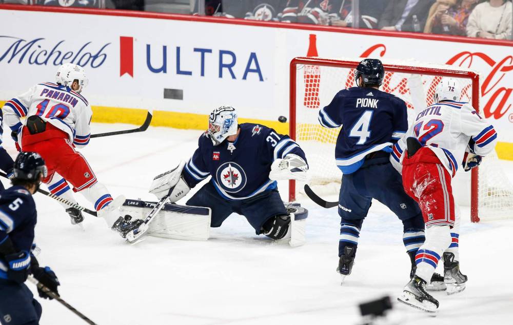 JOHN WOODS / WINNIPEG FREE PRESS
New York Rangers’ Artemi Panarin scores on Winnipeg Jets goaltender Connor Hellebuyck during the first period in Winnipeg on Monday.