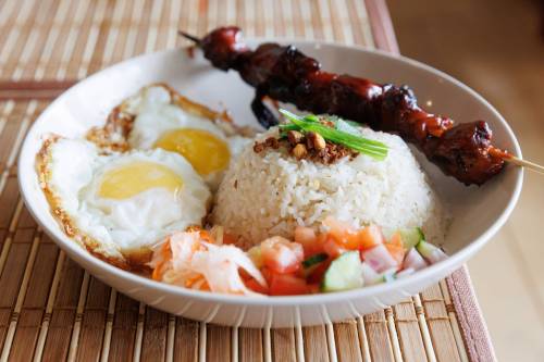 MIKE DEAL / WINNIPEG FREE PRESS
                                Pork BBQ Silog Platter is a hearty breakfast dish served with pork skewer, aromatic garlic fried rice, crispy fried eggs, atchara and salad.