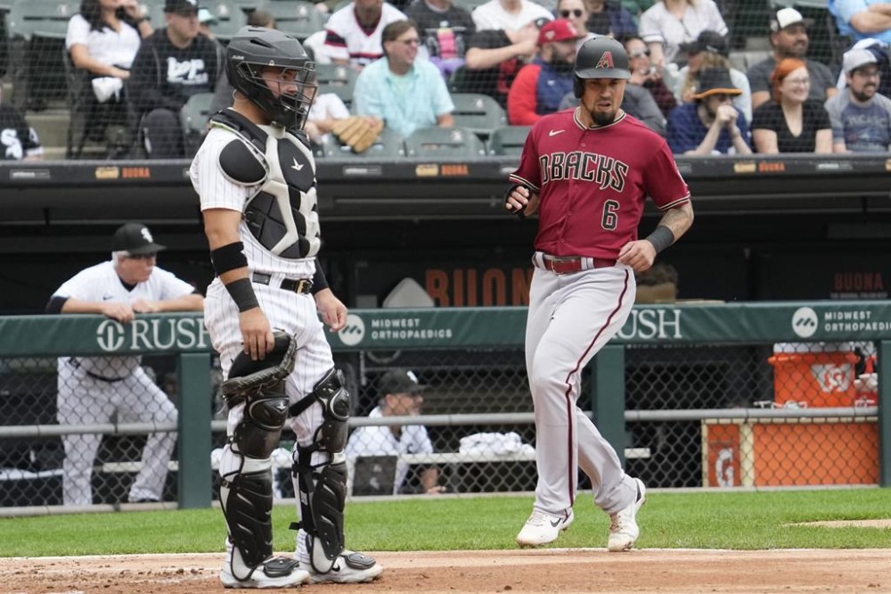 Arizona Diamondbacks' Jace Peterson, right, scores on a two-run double by Corbin Carroll as Chicago White Sox catcher Carlos Perez looks to the field during the third inning of a baseball game in Chicago, Wednesday, Sept. 27, 2023. (AP Photo/Nam Y. Huh)