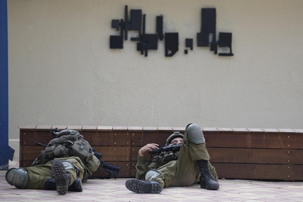 Israeli soldiers sleep near the police station that was overrun by Hamas militants on Saturday, in Sderot, Israel, Sunday, Oct.8, 2023. Hamas militants stormed over the border fence Saturday, killing hundreds of Israelis in surrounding communities. (AP Photo/Ohad Zwigenberg)