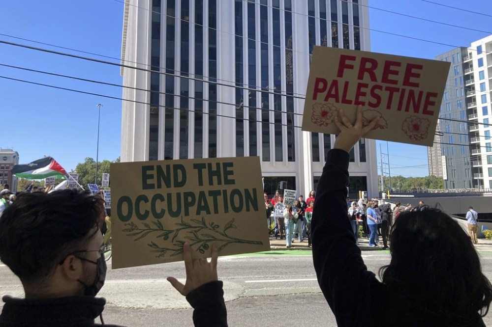Pro-Palestinian demonstrators chant slogans outside the Israeli consulate in Atlanta on Sunday, Oct. 8, 2023. Supporters of Israel and backers of the Palestinian cause rallied in many American cities Sunday over the conflict that has killed hundreds and wounded thousands in the Middle East. (AP Photo/Jeff Amy)