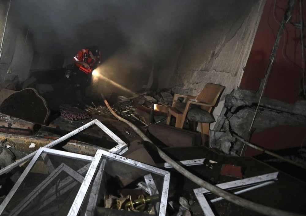 Palestinian civil defense crew looks through a house that was hit by an Israeli airstrike in Khan Younis, southern Gaza Strip, Sunday Oct. 8, 2023. (AP Photo/Yousef Masoud)