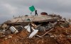 FILE - A Palestinian boy holds a Hamas flag over a destroyed house in Beit Lahia, northern Gaza Strip, Monday, Jan. 19, 2009. The Hamas militant group has issued its first statement, Monday, on losses suffered during Israel's latest offensive in the Gaza Strip, stating that the group lost 48 fighters, and the Health Ministry says more than 1,200 Palestinians died in the fighting. (AP Photo/Hatem Moussa, File)