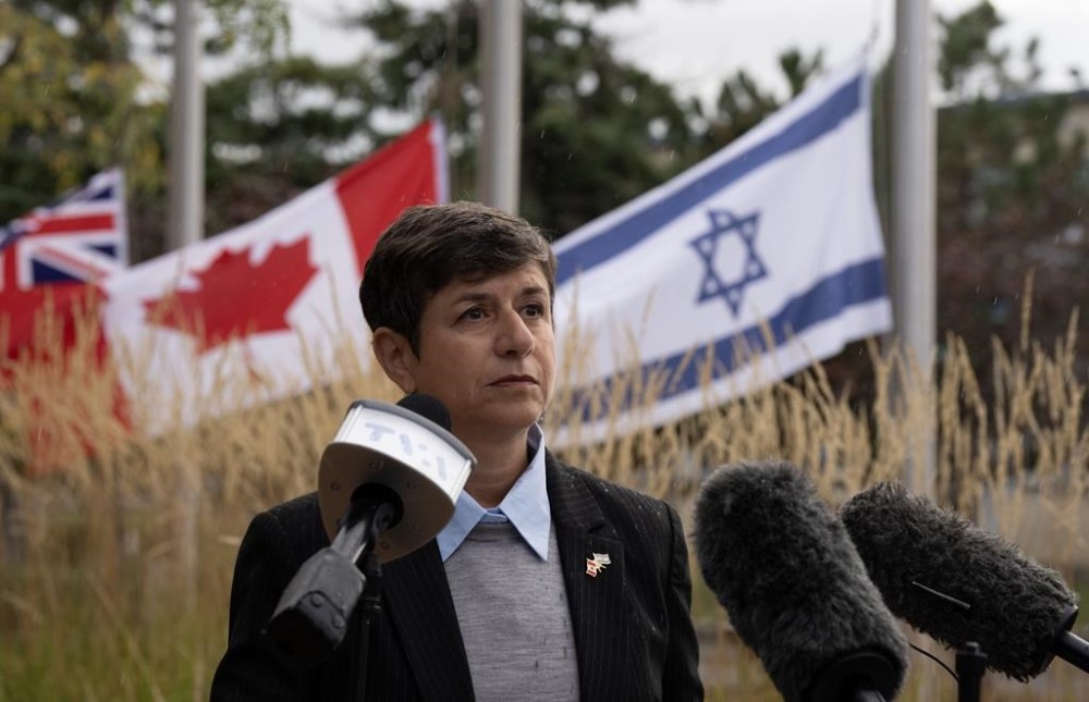 The flags of Ontario, Canada and Israel fly at half mast as Jewish Federation of Ottawa CEO Andrea Freedman reads a statement from the family of Adi Vital-Kaploun who was killed by Hamas, on Wednesday, October 11, 2023 in Ottawa. THE CANADIAN PRESS/Adrian Wyld