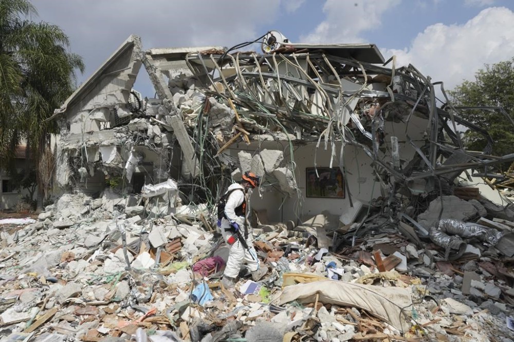 An Israeli soldier walks by a house destroyed by Hamas militants in Kibbutz Be'eri on Wednesday, Oct. 11, 2023. The kibbutz was overrun by Hamas militants from Neraby Gaza Strip Saturday when they killed and captured many Israelis. (AP Photo/Baz Ratner)