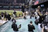 Arizona Diamondbacks pitcher Zac Gallen falls into the pool after the Diamondbacks defeated the Los Angeles Dodgers 4-2 in Game 3 to win a baseball NL Division Series, Wednesday, Oct. 11, 2023, in Phoenix. (AP Photo/Rick Scuteri)