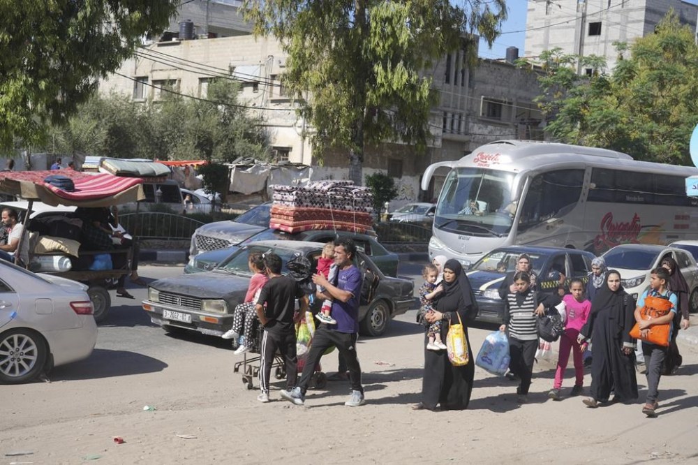 Palestinians flee to the southern Gaza Strip after the Israeli army issued an evacuation warning to a population of over 1 million in northern Gaza and Gaza City to seek refuge in the south ahead of a possible Israeli ground invasion, Friday, Oct. 13, 2023. (AP Photo/Hatem Moussa)
