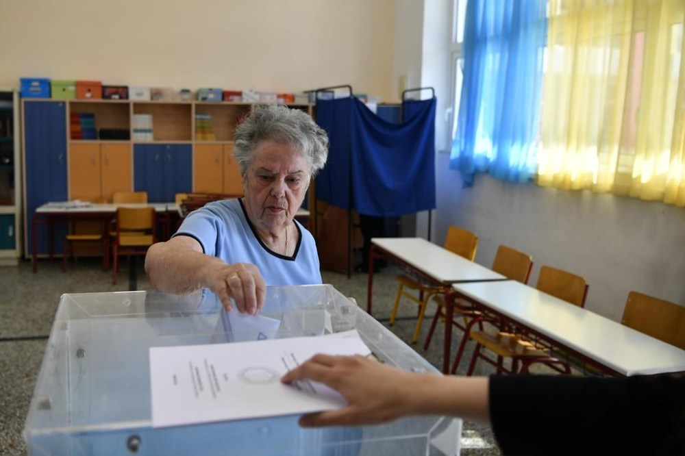 A woman casts her vote at a voting center during municipal elections, in Cholargos suburb, Athens, Greece, Sunday, Oct. 15, 2023. The country's two largest cities, and 6 of its 13 regions, are at play in Sunday's runoffs, with low turnout expected again. (AP Photo/Michael Varaklas)