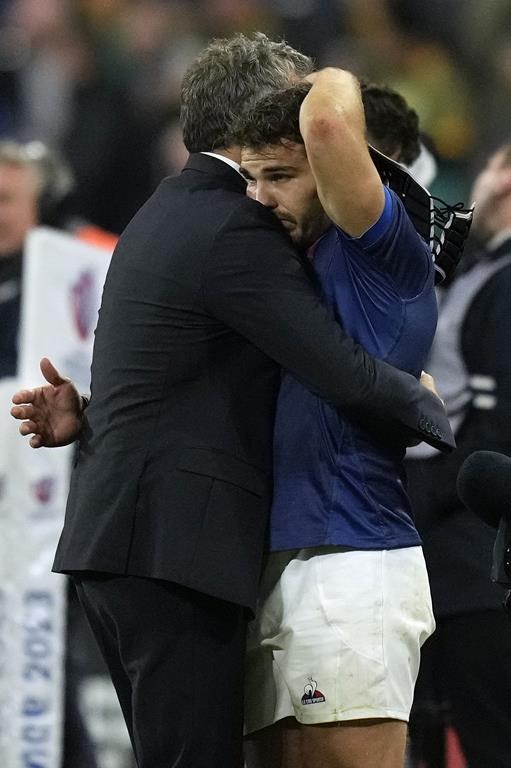 France's head coach Fabien Galthie consoles Antoine Dupont at the end of the Rugby World Cup quarterfinal match between France and South Africa at the Stade de France in Saint-Denis, near Paris Sunday, Oct. 15, 2023. South Africa won the match 29-28. (AP Photo/Thibault Camus)