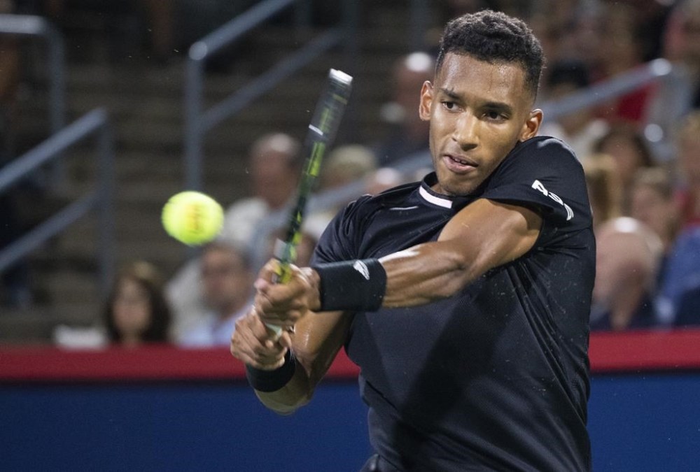 Canada's Felix Auger-Aliassime returns to Yoshihito Nishioka of Japan during second round of play at the National Bank Open tennis tournament Wednesday August 10, 2022 in Montreal. THE CANADIAN PRESS/Paul Chiasson