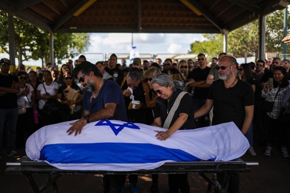 Relatives mourn during the funeral of Antonio Macias, killed by Hamas militants while attending a music festival in southern Israel, at Pardes Haim cemetery in Kfar Saba, Israel, Sunday, Oct. 15, 2023. (AP Photo/Francisco Seco)