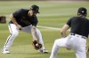 Arizona Diamondbacks' Jace Peterson, left, fields a grounder as he works out with third base coach Tony Perezchica Friday, Oct. 13, 2023, at Chase Field in Phoenix as the team prepares to play against the Philadelphia Phillies in the baseball NL Championship Series starting Monday. (AP Photo/Ross D. Franklin)